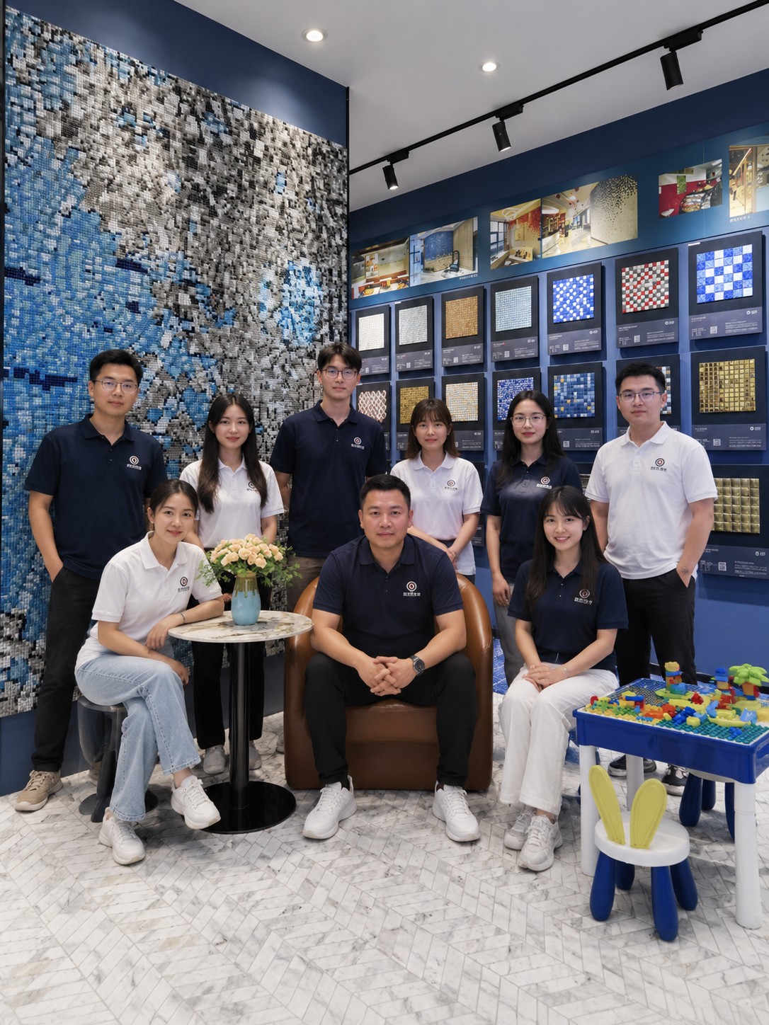 HUITLONG MOSAIC team in the showroom with blue mosaic display walls and product samples